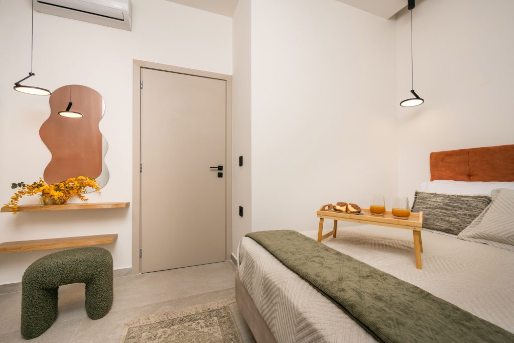 Bedroom with double bed, wall lighting, and decorative shelves at Mini City Center in Zakynthos Town